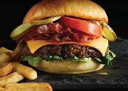 A stacked burger with fries